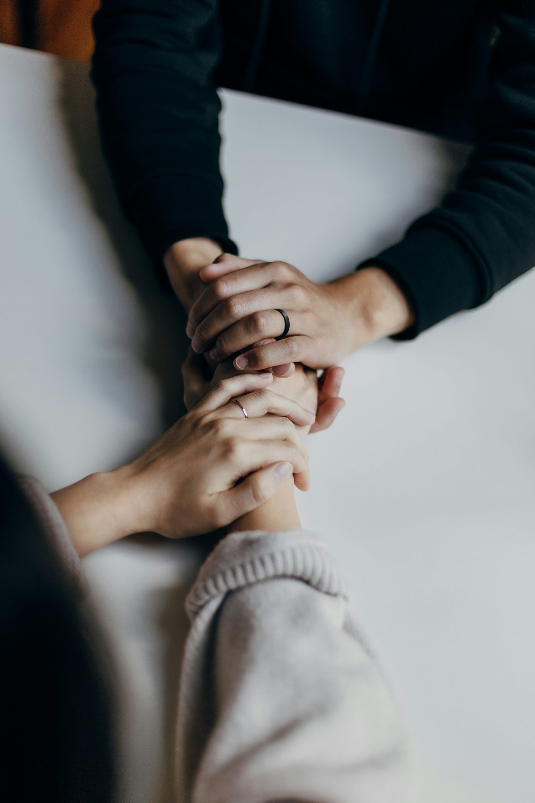 Married couple holding hands, sitting at a table | Do Funeral Homes Have Payment Plans? How Families Pay | Family Funeral Funding - Helping Families with After Death Expenses | Bridging the gap between families, funeral homes and life insurance companies.